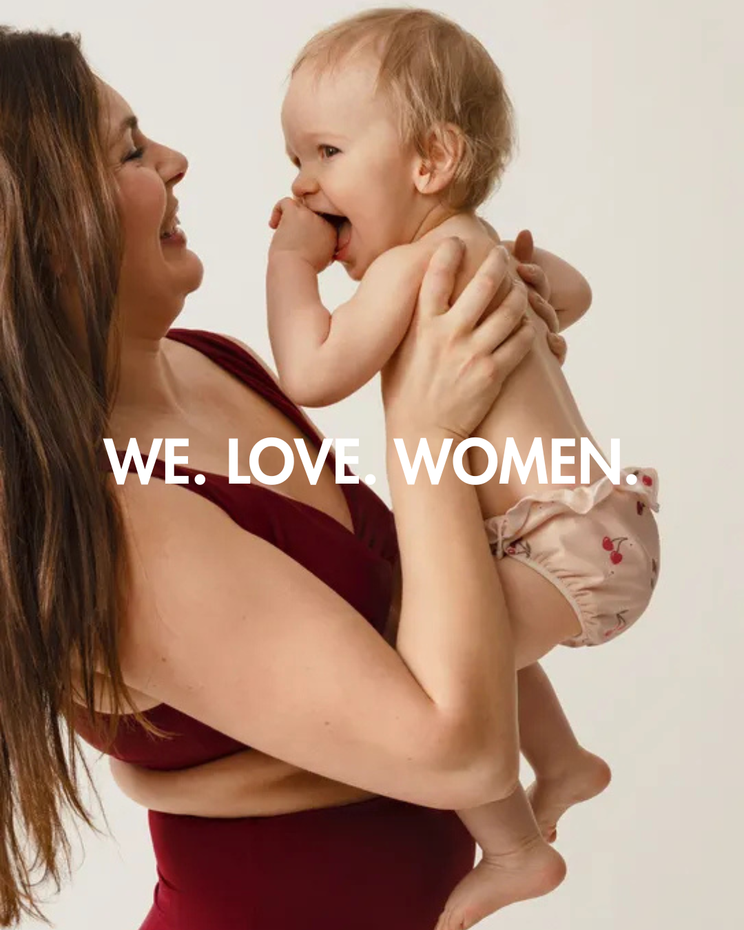 Mamma i bikini håller bebis i badblöja. 